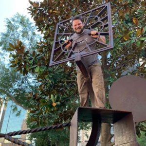 picture of Earl Dismuke with a metal sculpture.